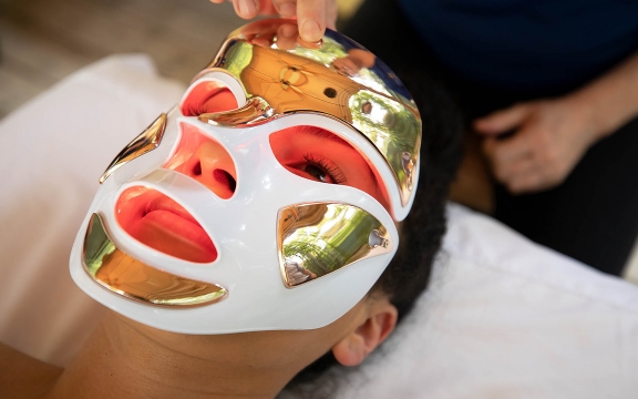 A woman receives a facial with a mask on